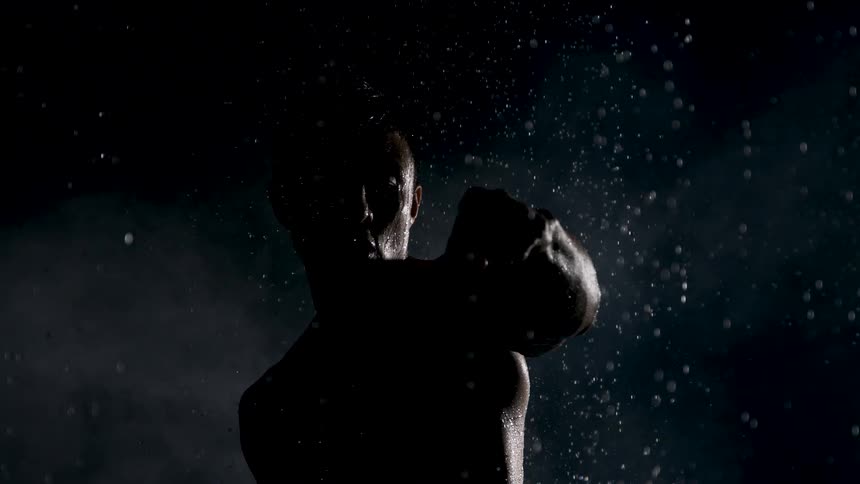 Fighter trains beneath droplets of water reflecting the light