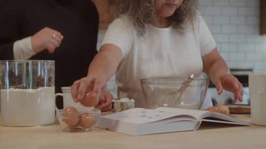 Woman arranges ingredients on the table while following an open recipe
