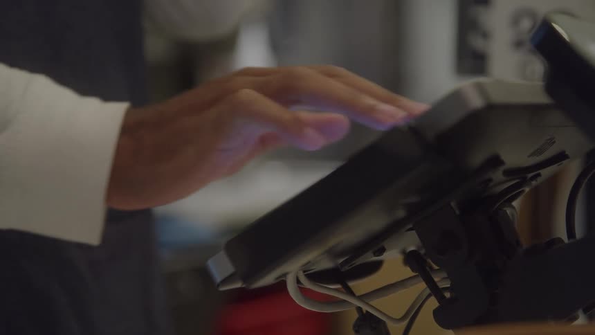 Hand touches the screen of an electronic terminal indoors