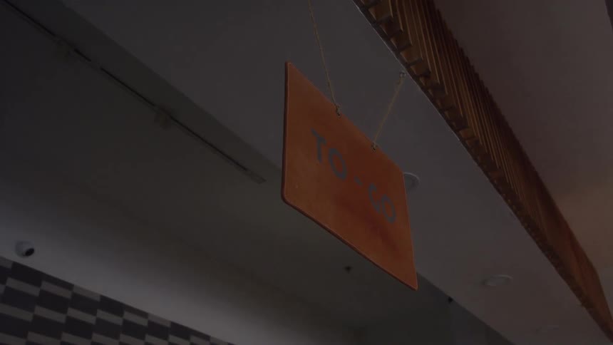 A view of a to go sign hanging in a restaurant