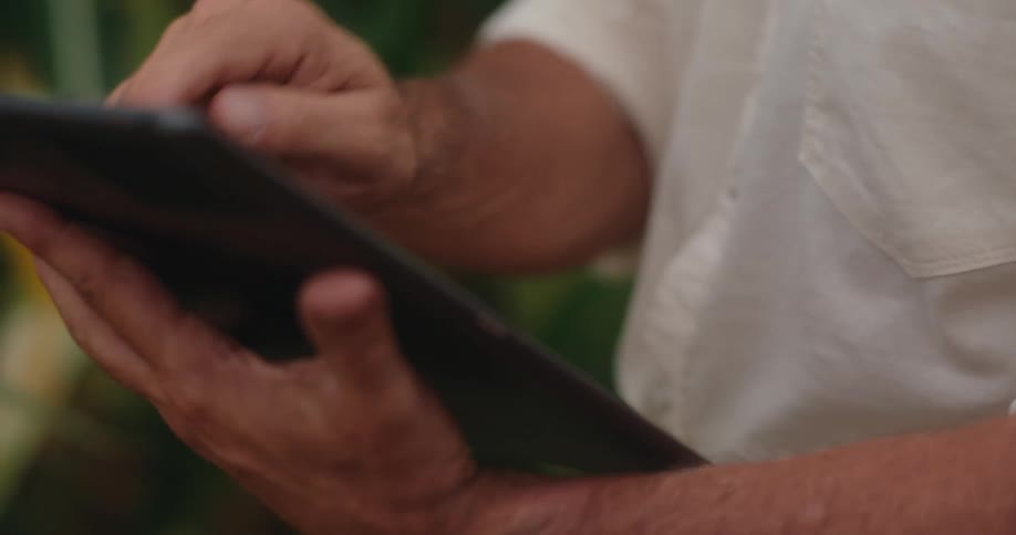 Man standing outdoors makes selections on a tablet