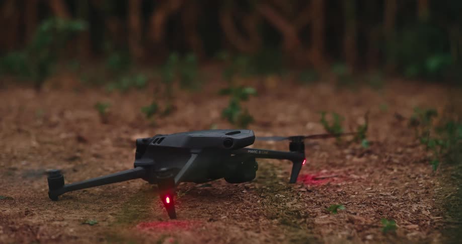 A drone is on the ground resetting before taking off flying upwards next to a cornfield