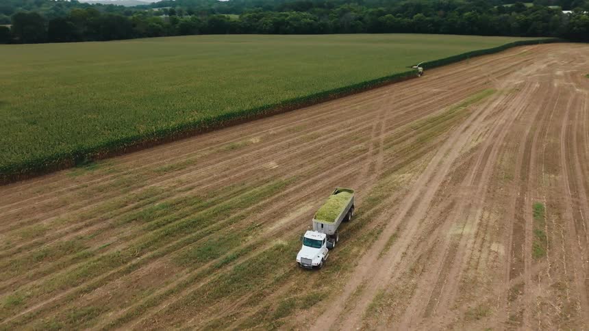Truck travels across the dirt next to farmland