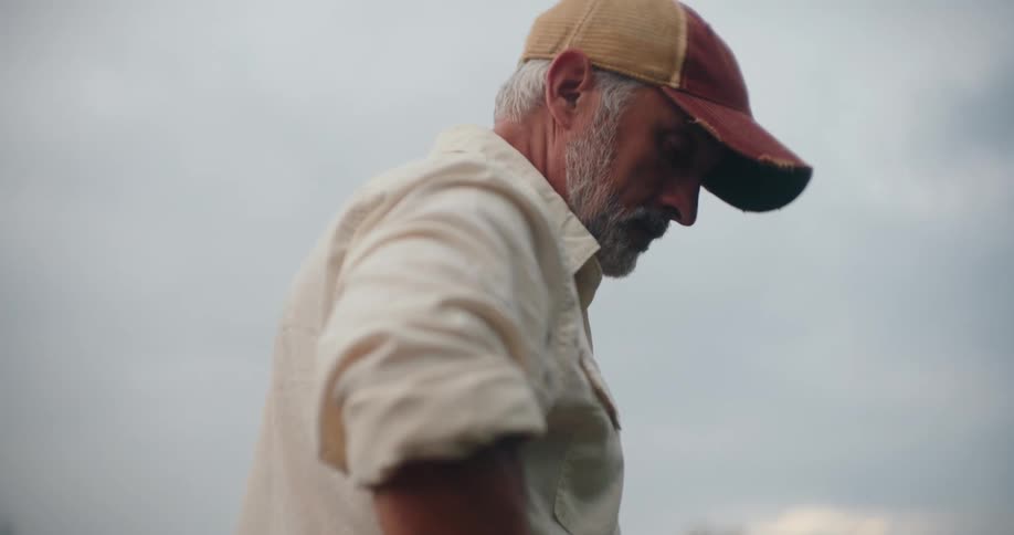 Man looks toward the horizon with a thoughtful expression under the gray sky
