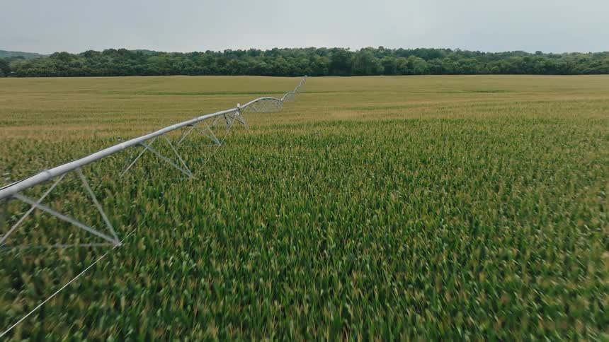 Irrigation boom stretches across crops on farmland