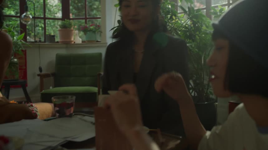 Woman clapping while smiling in a room filled with plants