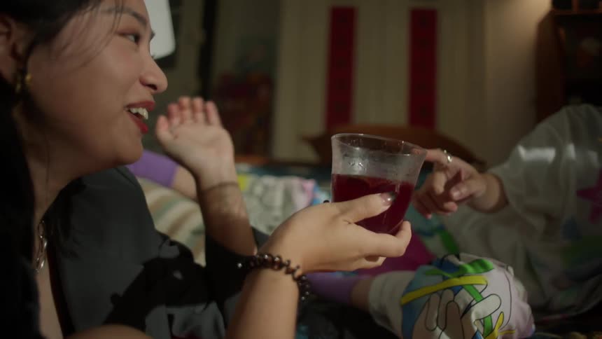 Two friends sharing a drink while sitting on the couch in the living room