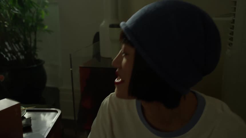 Friends gather in a softly lit room laughing and enjoying snacks together