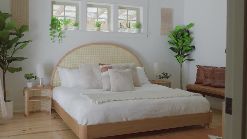 Interior decoration of a bedroom with plants on the windowsill and pillows on the bed