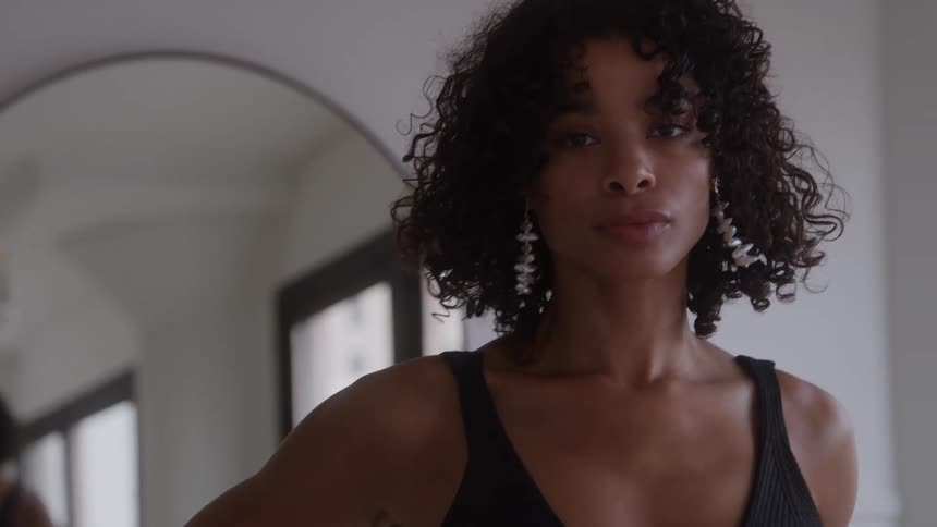 The woman looks at herself in the mirror then turns around