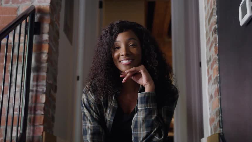 Woman sitting on her front porch as she turns her head and smiles