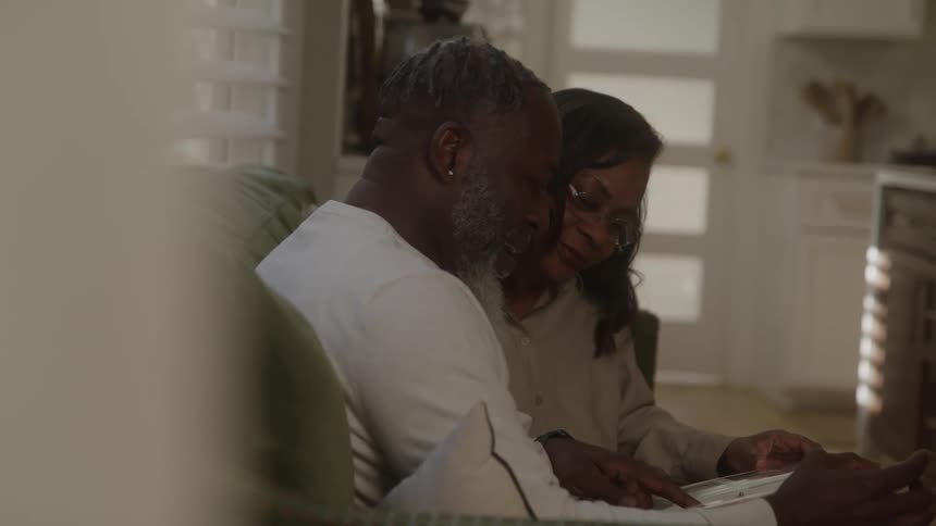 Man and woman sitting together looking through a notebook