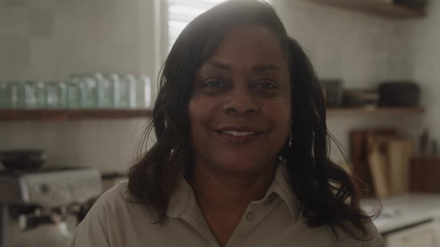 Woman smiles while standing in a kitchen during the daytime