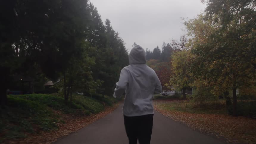 An adult jogs down a residential street on an autumn day