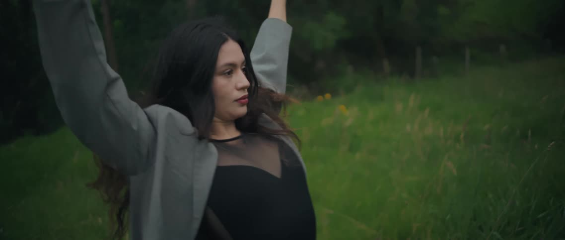 The woman is dancing and waving her arms