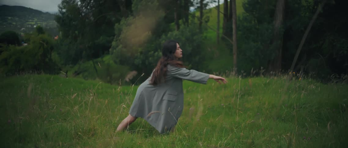 A woman dancing in a field outdoors