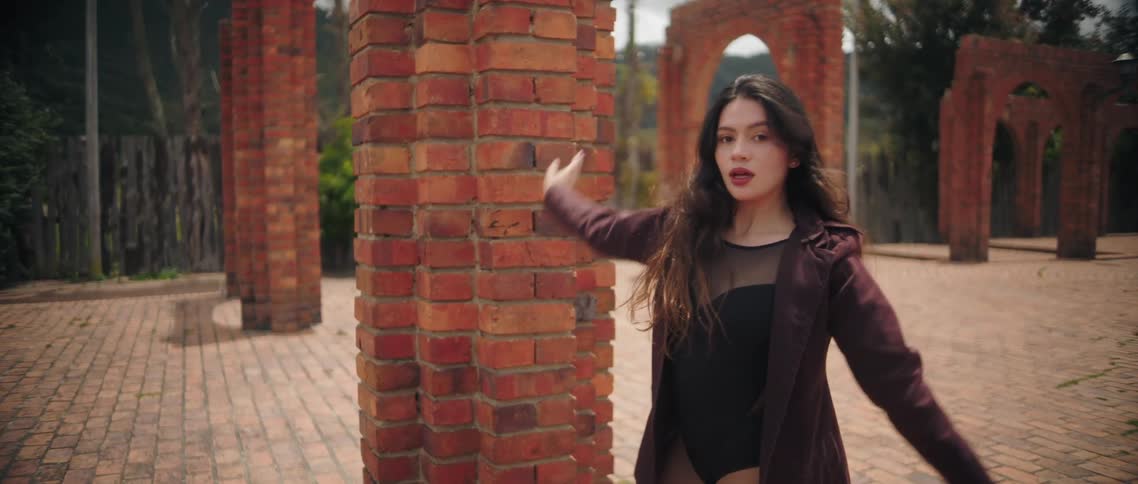 The woman dances on the brick walkway
