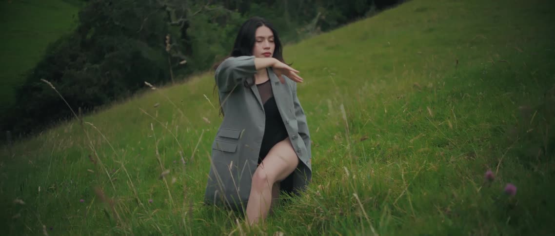 Woman dances in a sloping pasture in the rural countryside on an autumn day