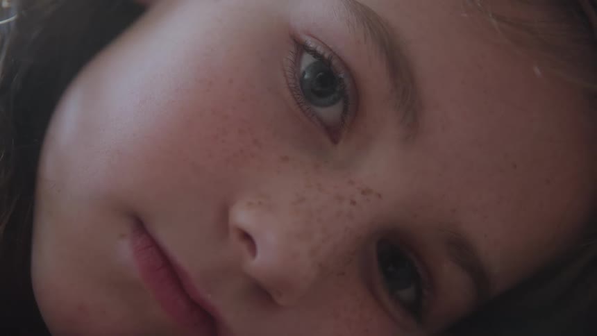 A close up of a little girl who is on looking forward with a sad look