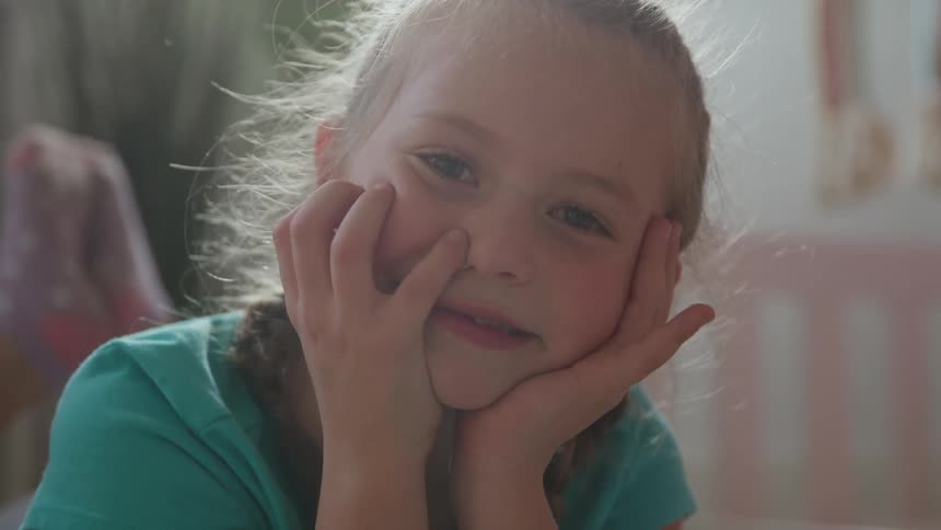 Female child lying down on the floor smiling indoors during day time