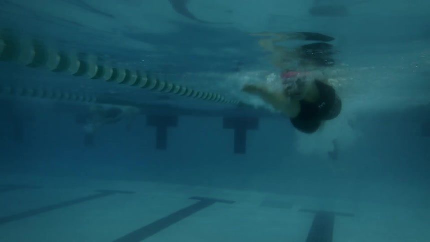 Person swims under water in a swimming pool
