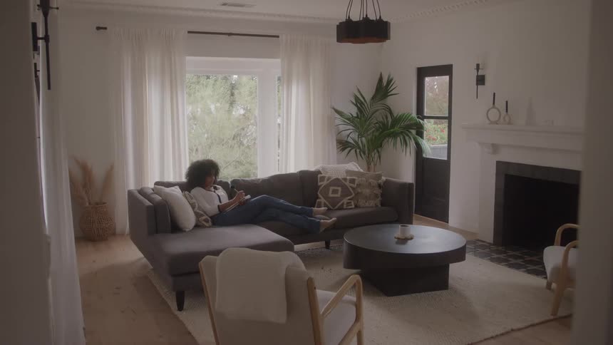 Woman lying down writing in a modern living room