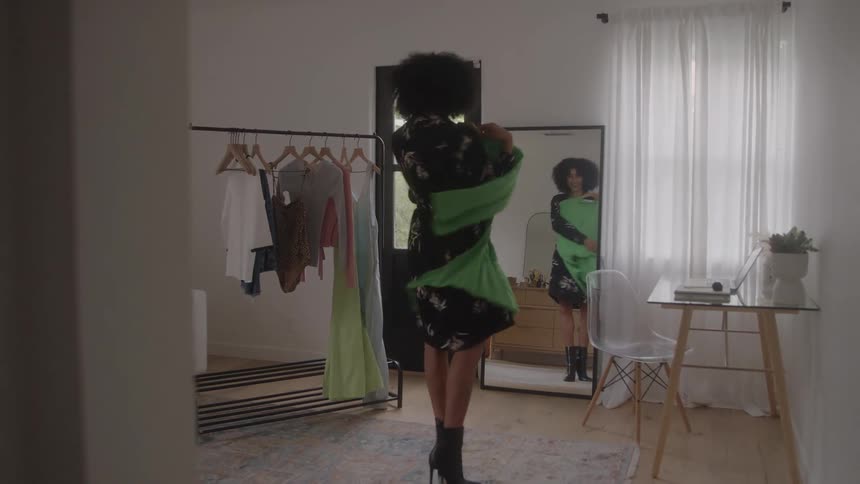 Woman trying on clothing in front of the mirror in the bedroom