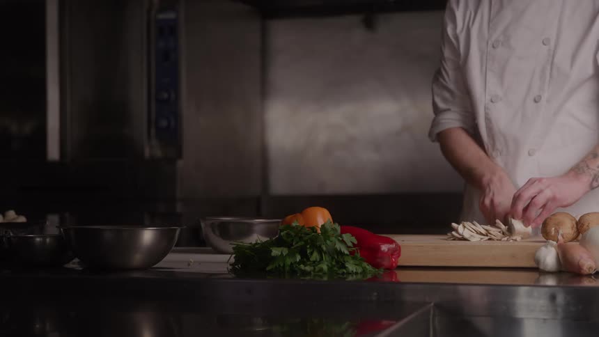 The chef is cutting up vegetables in the kitchen