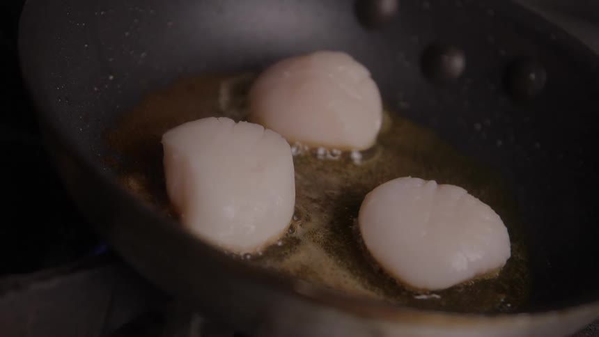 Close up of food balls frying in a pan placed on a cooker in the kitchen