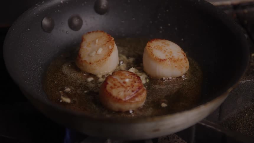 Close up of food balls frying in a cooking pan on a gas cooker in a kitchen
