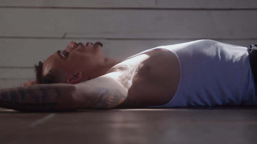 Man lying on the floor takes deep breaths while regaining his breath