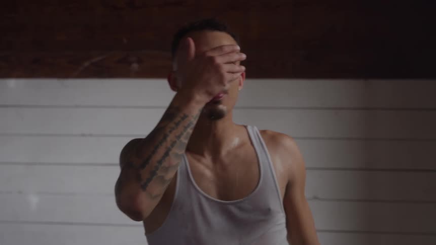 Man pouring water over his head while catching his breath