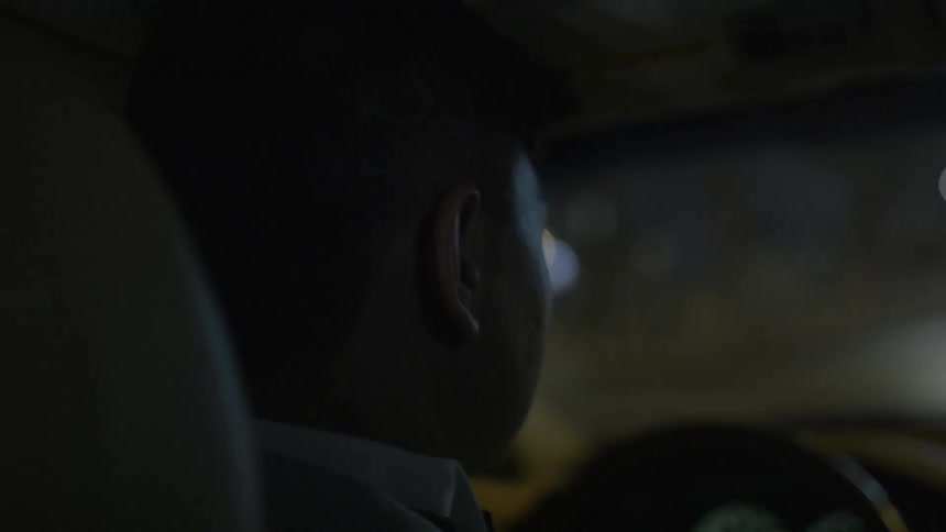 A man is sitting in his car at night