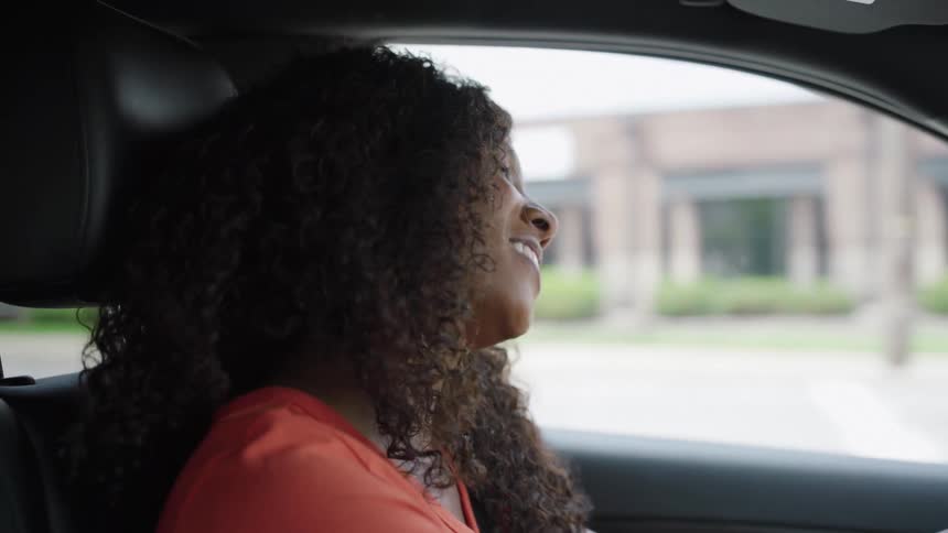 Young woman sings as she drives in traffic