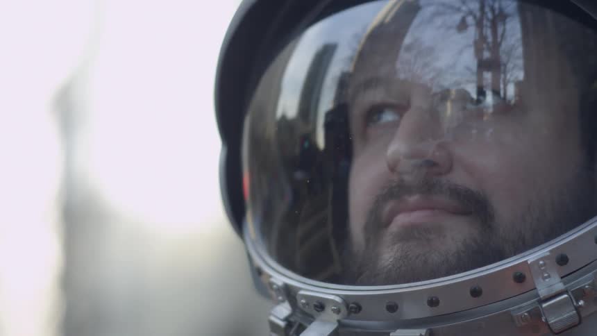 A man closes the lid on his space helmet