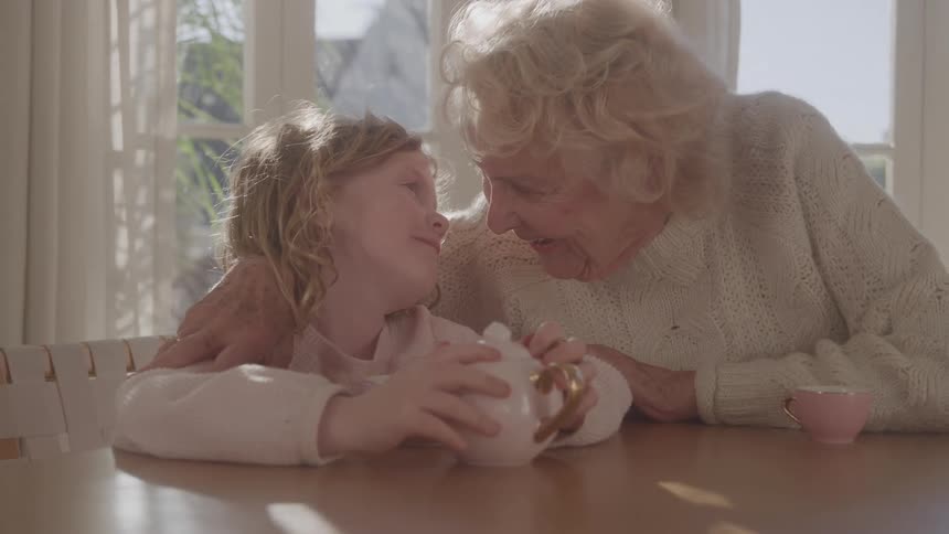 Grandmother and granddaughter are having a tea party