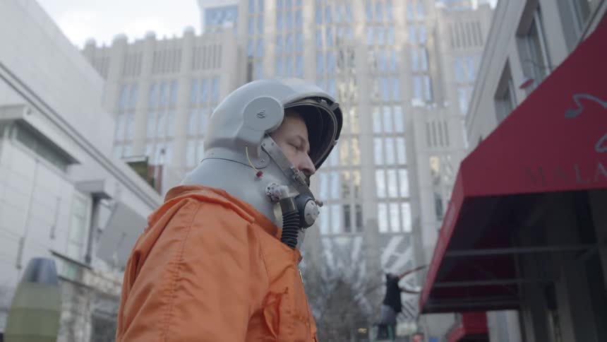 Man wearing a helmet walks through a city