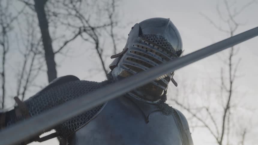 The knight in armor pulls out his sword