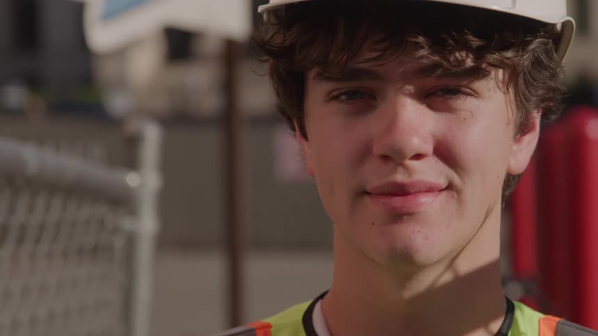 Young person with white helmet and reflective vest
