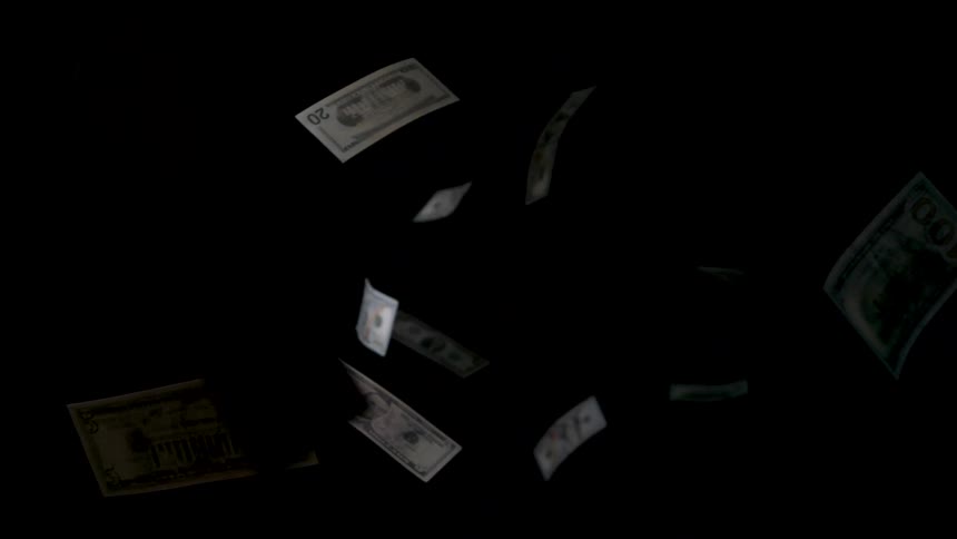 Dollar bills fall against dark background