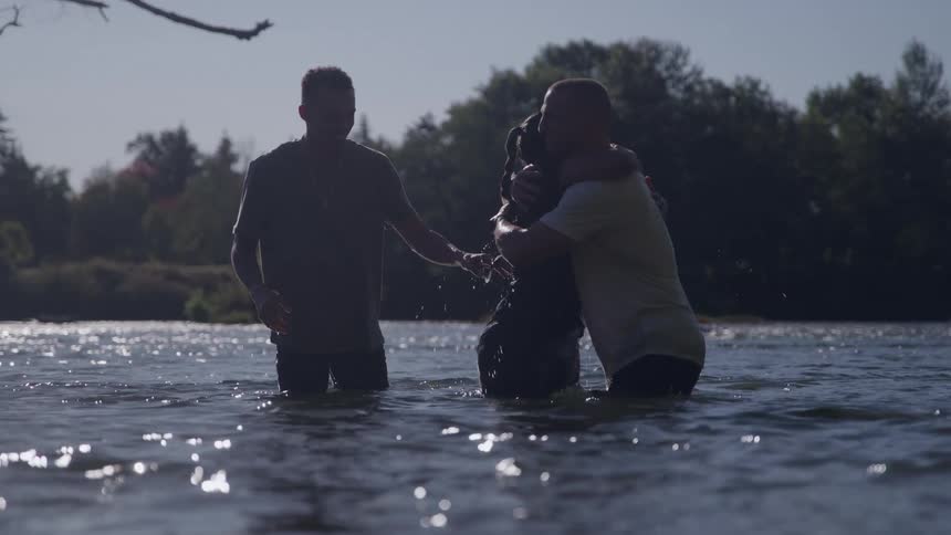 A man and woman hugging in a river