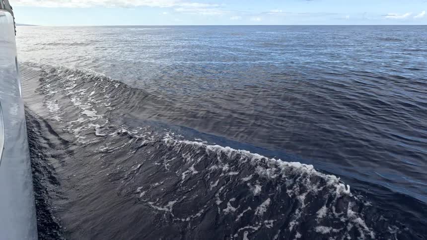 Water ripples and waves as a boat sails across the open sea