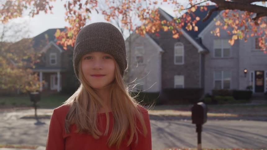 A portrait of a girl standing outdoors
