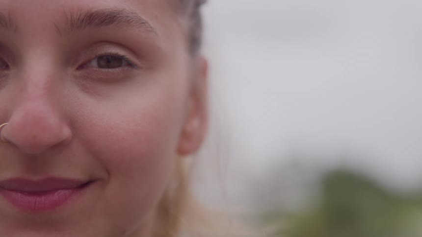 Closeup of womans face with nose ring in outdoor setting