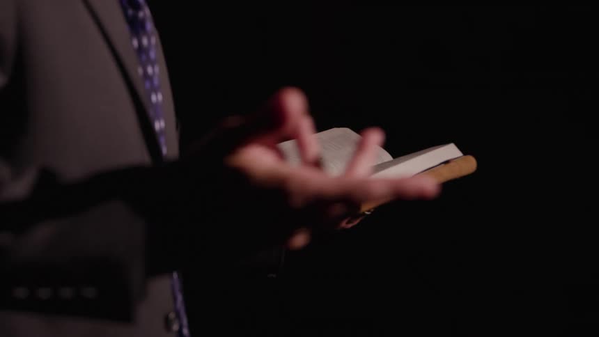 A man reading from an open book