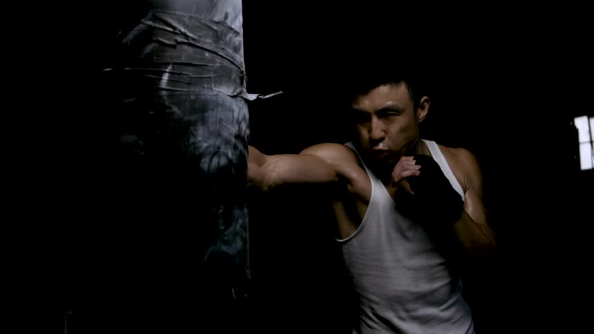 The man is punching the heavy bag