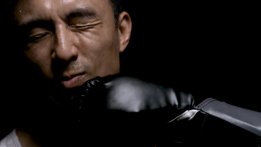 The man is punched in the face with a boxing glove