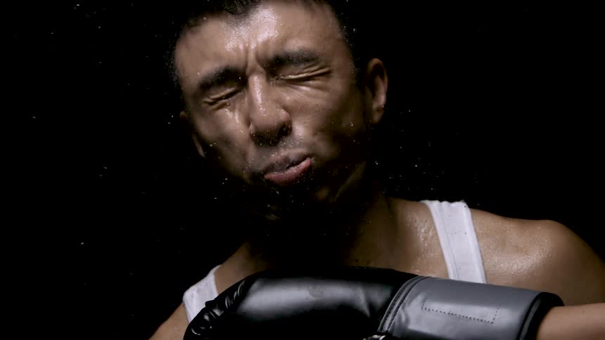 Sweat flies off the man as he is punched
