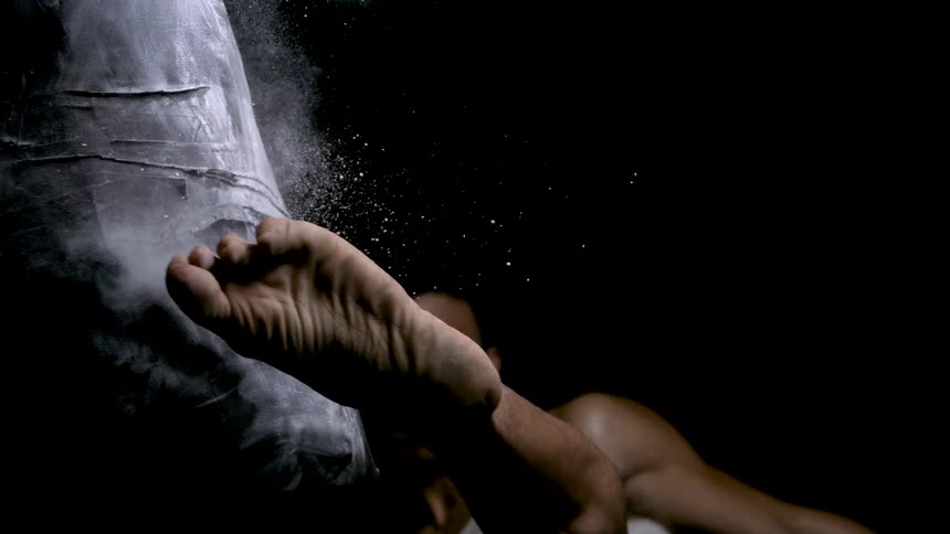 Foot strikes the punching bag as the dust disperses into the air