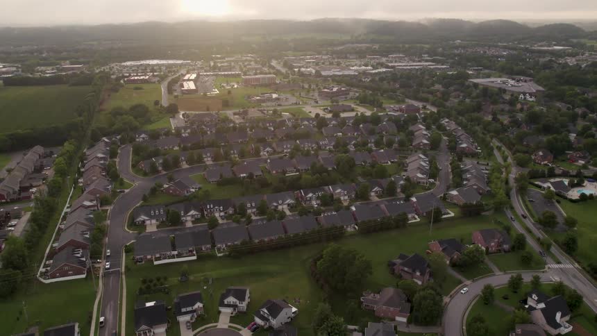 Residential neighborhood stretches along winding streets under soft morning light